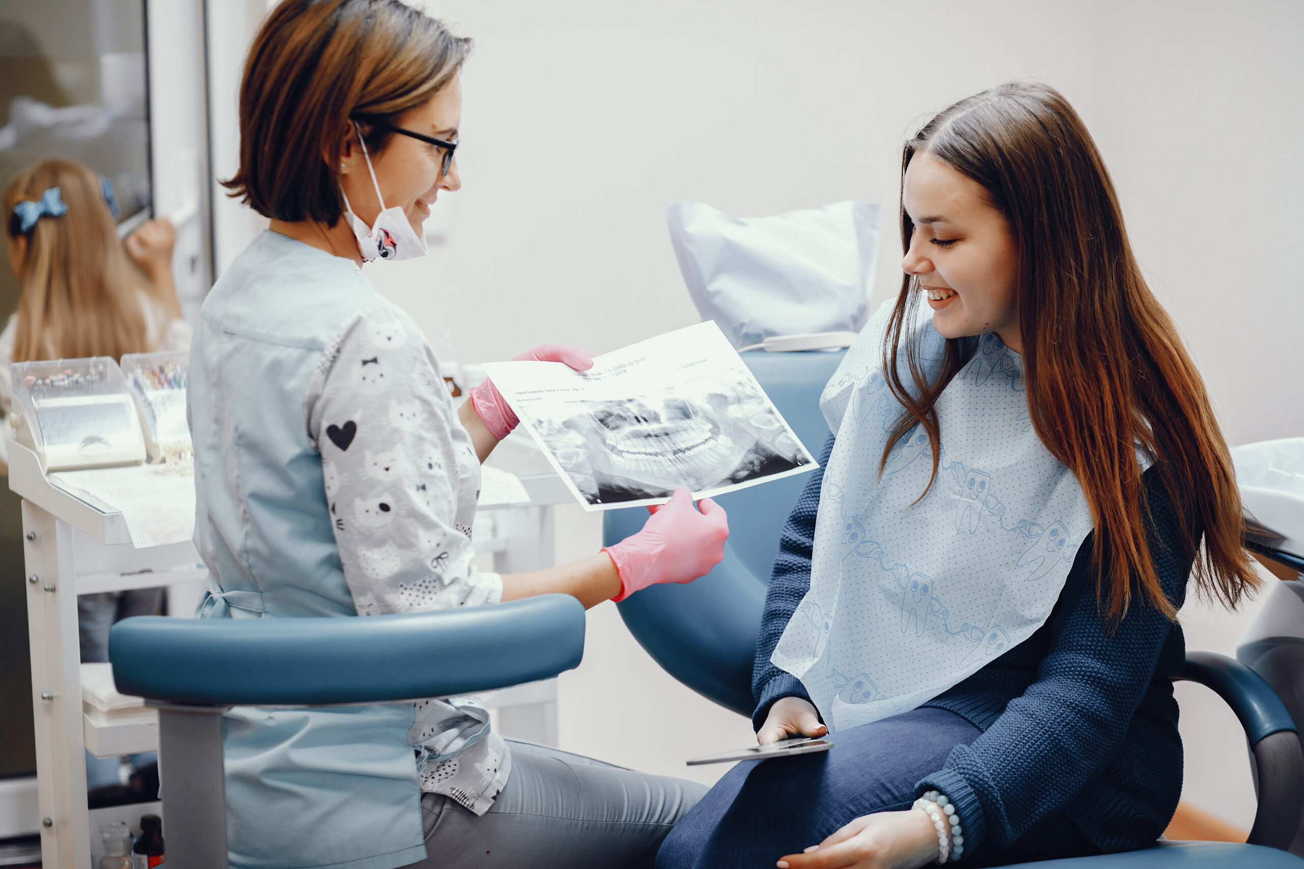 Girl talking to the dendist. Beautiful lady in the dentist's office. Woman in a uniform