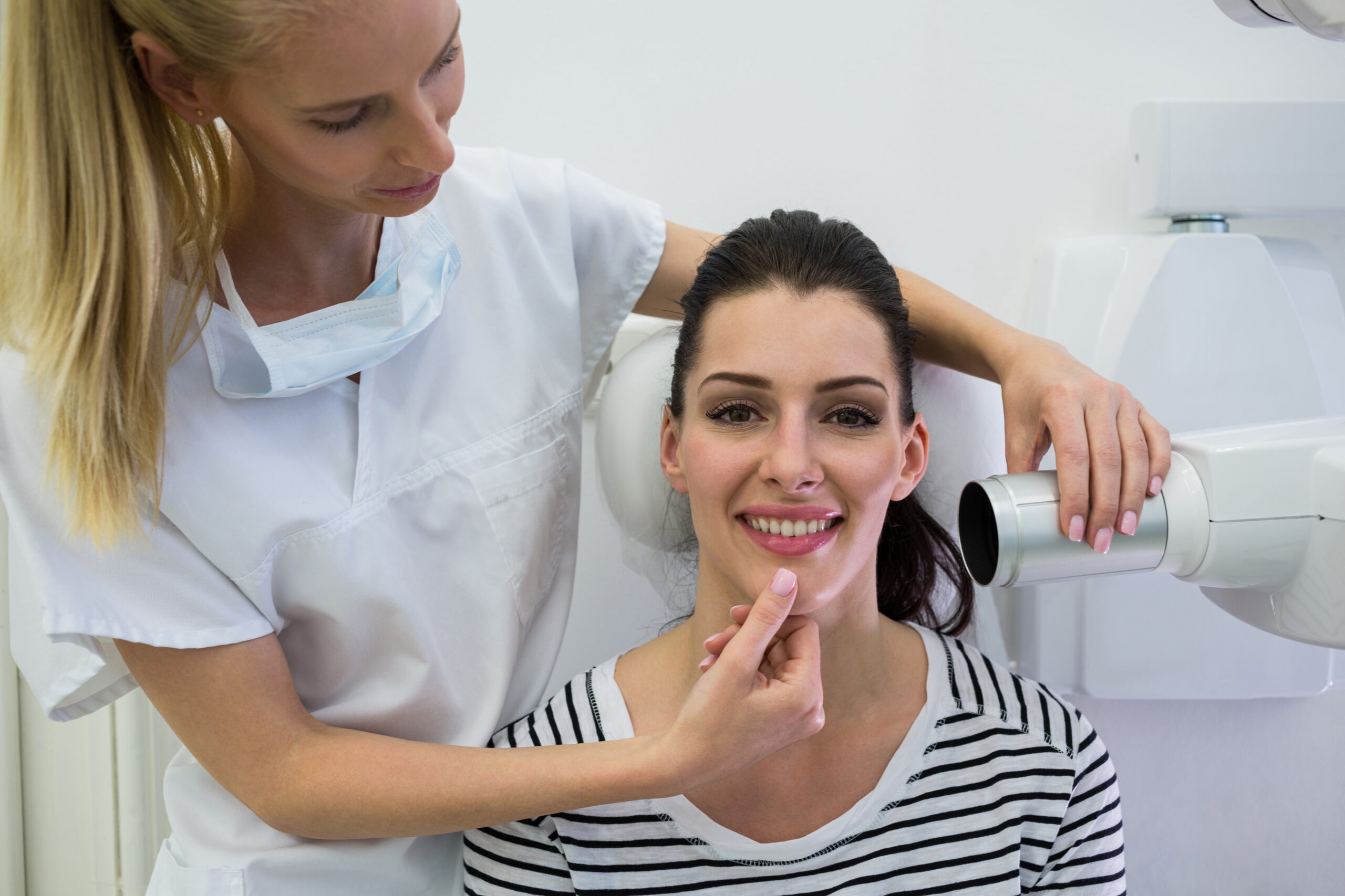Dentist taking a female patients tooth x-ray in clinic